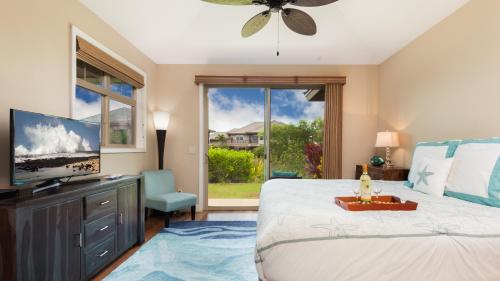 ein Schlafzimmer mit einem großen Bett und einem TV in der Unterkunft SWEET ESCAPE Stylish KaMilo 3BR Home with Private Beach Club Bikes in Waikoloa