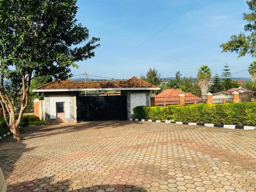 a garage with a brick driveway in front of a house at Quiet and Spacious Hidden Gem in Kigali with Breathtaking Views right by the Airport in Kigali