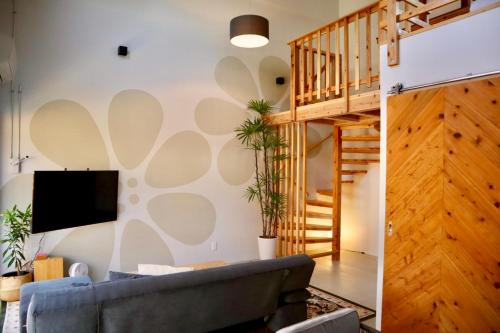 sala de estar con escalera y sofá en Hotel Little Swiss House en Motobu