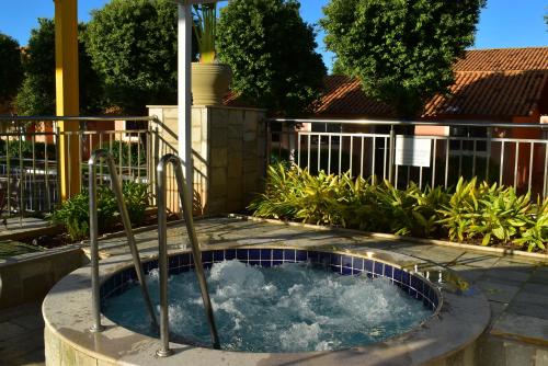 a hot tub in a yard with a fence at diRoma Fiori - Apartamentos JN in Caldas Novas