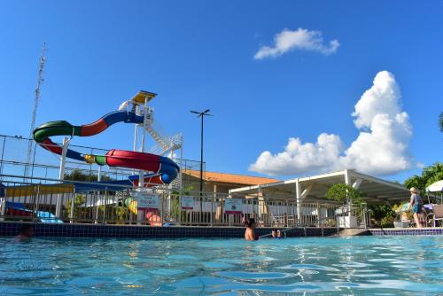 a swimming pool with a slide in the water at diRoma Fiori - Apartamentos JN in Caldas Novas