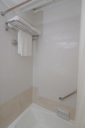 a bathroom with a shower with a white towel at Ramada Hong Kong Grand View in Hong Kong