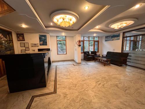 een woonkamer met een bank en een tafel bij Happy Valley INN in Jamnagar