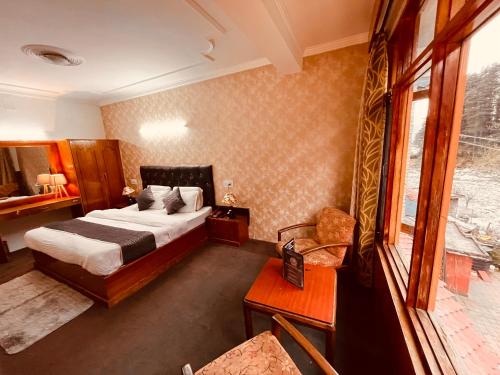 um quarto de hotel com uma cama e uma janela em Happy Valley INN em Jamnagar