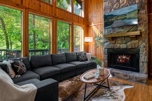 a living room with a couch and a fireplace at Escape to Sugar Chalet: The Rustic Modern Retreat in Gatlinburg