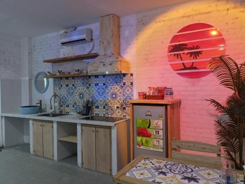 eine Küche mit einem Kühlschrank und einer rosa Wand in der Unterkunft Harbor Homestays in Hanoi