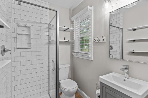 a white bathroom with a toilet and a sink at The Blue Wave Quiet & Cozy Beach Retreat in Oak Island