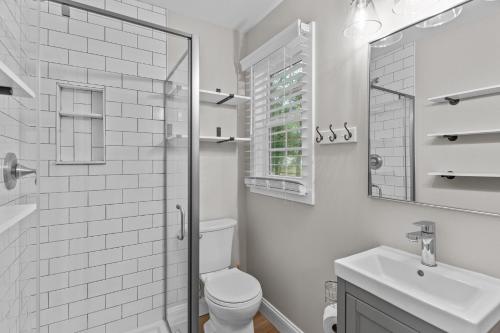 Un baño blanco con inodoro y lavabo. en The Blue Wave Quiet & Cozy Beach Retreat, en Oak Island