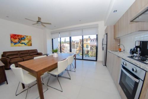 a kitchen and living room with a wooden table and chairs at Versalles Vista at Roma 240 in Puerto Vallarta