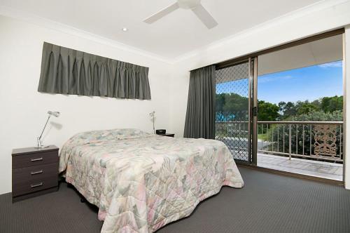 a bedroom with a bed and a large window at Pacific Palms 4 Unit 4, 9-11 Terrace St Evans Head in Evans Head