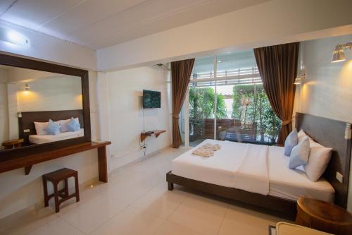 1 dormitorio con cama y ventana grande en Kallapangha Resort Khlongwan, en Klong Wan