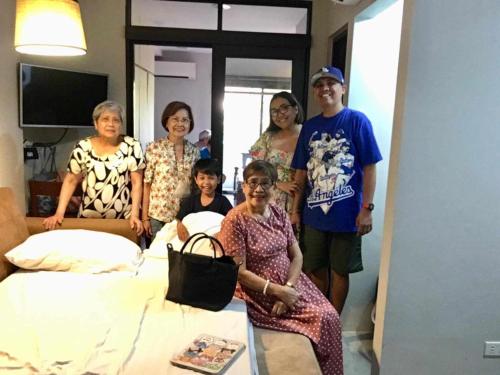 a group of people standing around a bed at 2F Vivere Condo - Govantes Properties in Vigan