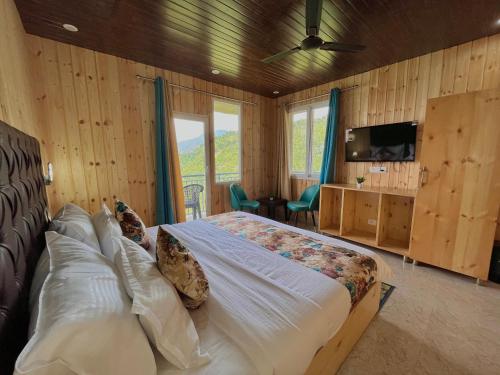 um quarto com uma cama grande e uma televisão. em Bhupesh Lodge em Rajkot