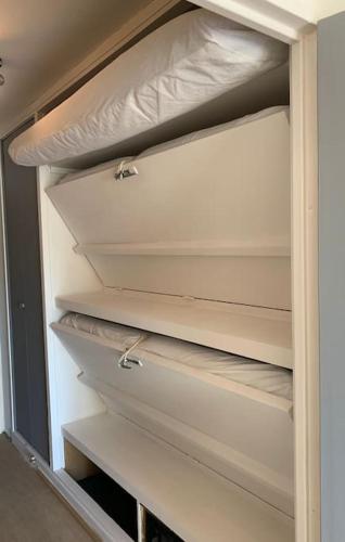 un placard vide avec deux étagères dans une pièce dans l'établissement Charmant studio, vue mer, à deux pas de la plage, à La Grande Motte