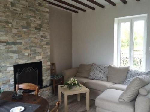 un salon avec un canapé et une cheminée dans l'établissement Familly Home, à Grandcamp-Maisy