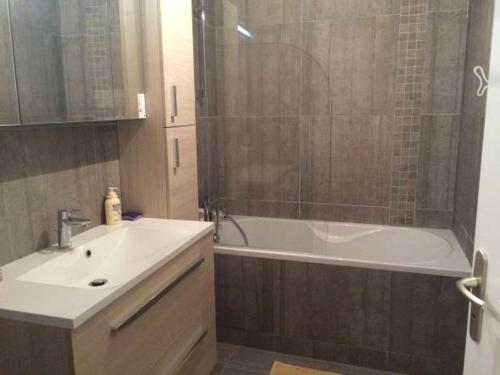 une salle de bain avec une baignoire, un lavabo et une douche dans l'établissement Familly Home, à Grandcamp-Maisy