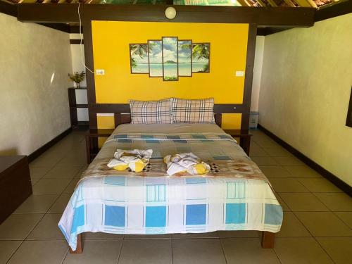 Serenity Bungalows في Port-Olry: غرفة نوم مع سرير مع اثنين من الحيوانات المحشوة عليه