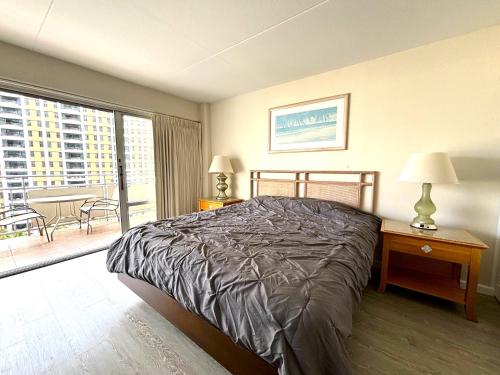 ein Schlafzimmer mit einem Bett und einem großen Fenster in der Unterkunft Ilikai Apt 1042 - Spacious Studio with Ocean-Lagoon Views in Honolulu