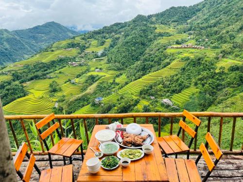 een tafel met eten erop met uitzicht op een berg bij Hill home Hoang Su Phi in Nam Pi