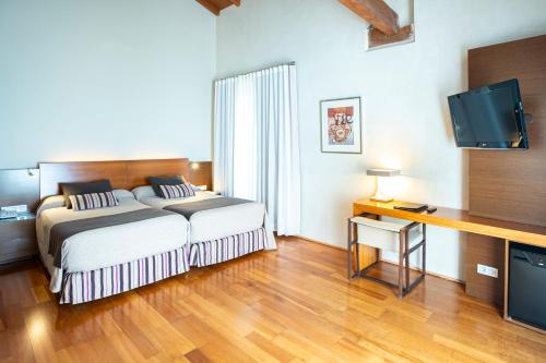 サン・マルティン・デ・トレベホにあるHospedería Conventual Sierra de Gataのベッドルーム(ベッド1台、薄型テレビ付)