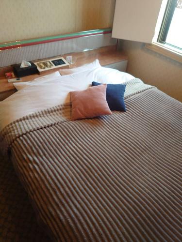 1 dormitorio con 1 cama con 2 almohadas en openHeart城『キャッスル』, en Ōami