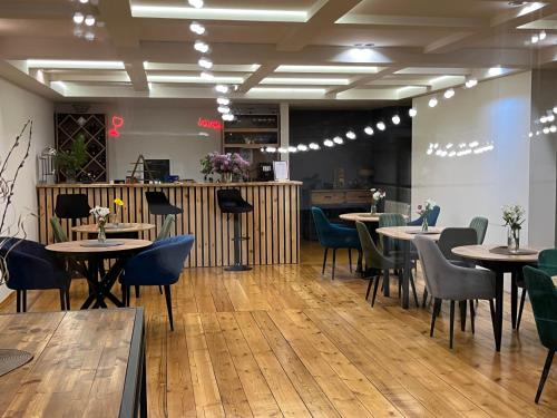 un ristorante con pavimenti e tavoli in legno e sedie di Arevaham Boutique Hotel a Stepanavan
