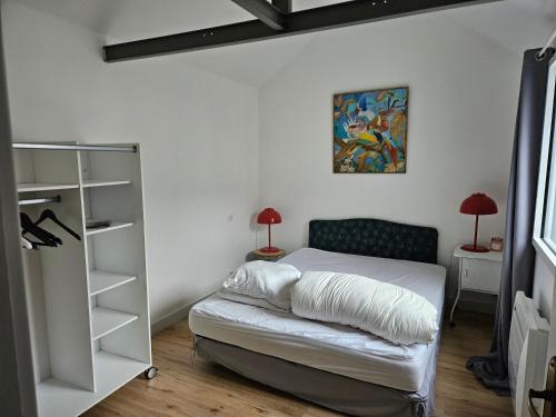 een slaapkamer met een bed en een boekenplank bij Maisonnette à Batz sur Mer centre 8min des plages à pieds in Batz-sur-Mer