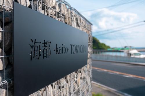 a sign on the side of a building with a bridge in the background at 海都-kaito- TOKYOBAY in Futtsu