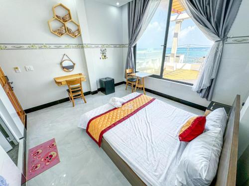 Schlafzimmer mit einem Bett, einem Schreibtisch und einem Fenster in der Unterkunft homestay Phúc Lũy in Cu Lao Thu