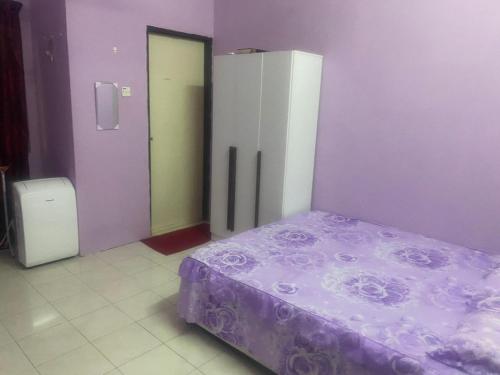 um quarto com uma cama e uma parede roxa em MyLittle Homestay em Tanjung Malim