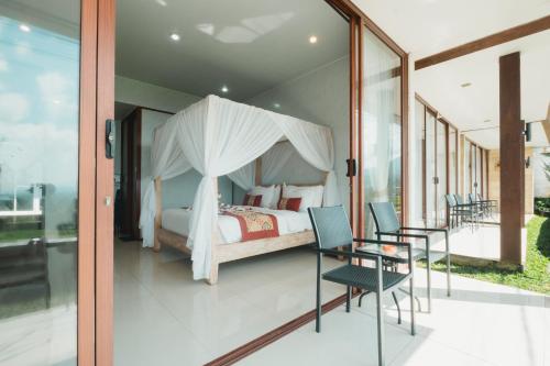 a bedroom with a bed and a table and chairs at Bhuana Agung Villa and Restaurant in Jatiluwih