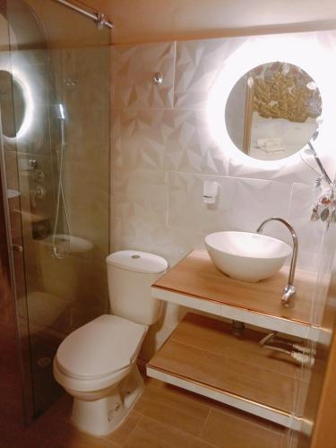 La salle de bains est pourvue de toilettes, d'un lavabo et d'une douche. dans l'établissement Sumerceé Hospedaje Boutique Restaurante Bistro, à Santa Sofía