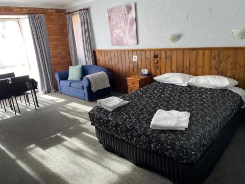 a hotel room with a bed and a chair at Corryong County Inn in Corryong