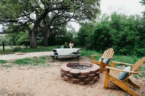 a fire pit with two chairs and a picnic table at Hadley's House - A Country 3 Bdrm with Screened-In Porch in New Braunfels
