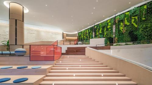 a lobby with stairs and plants on the walls at EVEN Hotel Yinchuan Yuehai by IHG in Yinchuan