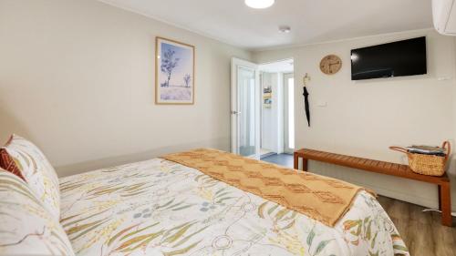 Schlafzimmer mit einem Bett und einem Flachbild-TV in der Unterkunft Badger's View Farmstay Cottage in Railton