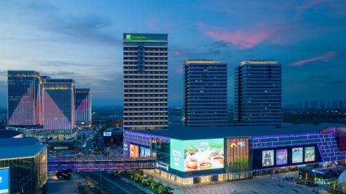 a group of tall buildings in a city at night at Holiday Inn Tianjin Xiqing by IHG in Tianjin