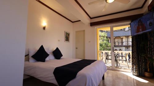 1 dormitorio con 1 cama y balcón en Mermaid Resort and Dive Center, en Puerto Galera