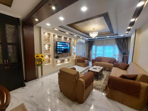 a large living room with couches and a tv at Luxurious vip apartment in Cairo