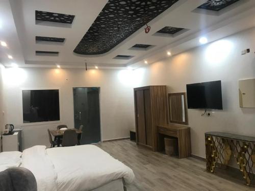 a bedroom with a bed and a flat screen tv at Moonlight in Taif
