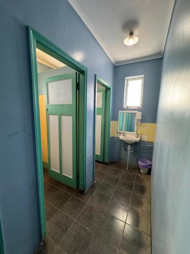 a bathroom with a green door and a sink at Ayr Budget Accommodation in Ayr