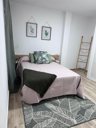 1 dormitorio con 1 cama con manta y alfombra en Solera, en Jerez de la Frontera