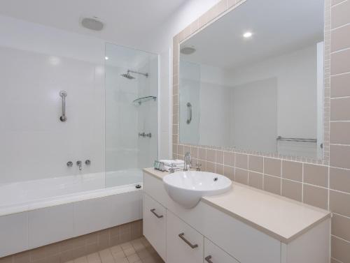 ein weißes Badezimmer mit einem Waschbecken, einer Badewanne und einer Dusche in der Unterkunft Stunning She Oak Lane - 2 Bedroom Apartment! in Casuarina