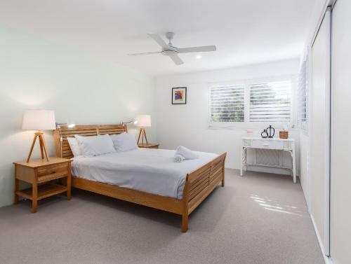 una camera bianca con un letto e una finestra di Stunning She Oak Lane - 2 Bedroom Apartment! a Casuarina