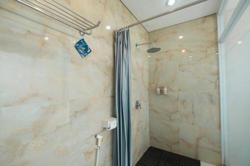 a bathroom with a shower with a glass door at Bhuana Agung Villa and Restaurant in Jatiluwih