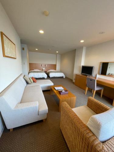 a hotel room with two beds and a living room at Wisterian Life Club Toba in Toba