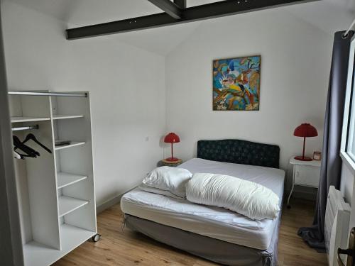 a bedroom with a bed and a book shelf at Deux maisons reunis par le jardin et sa cabine de plage, à 8min à pieds des plages et de l'océan in Batz-sur-Mer