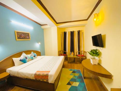 um quarto de hotel com uma cama e uma televisão em Hotel Tara INN with terrace and mountain view em Shimla