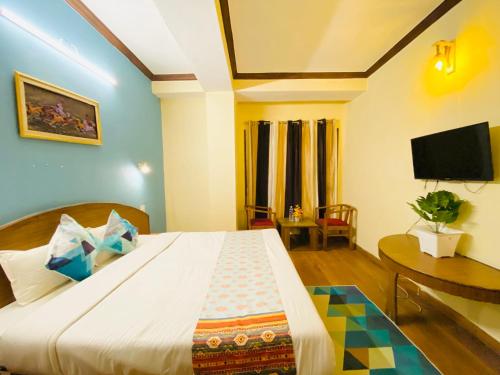 um quarto com uma cama grande e uma televisão em Hotel Tara INN with terrace and mountain view em Shimla