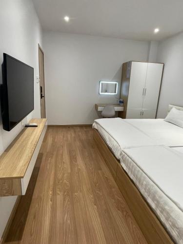 ein Hotelzimmer mit einem Bett und einem Flachbildfernseher in der Unterkunft The CK Hotel in Chau Doc